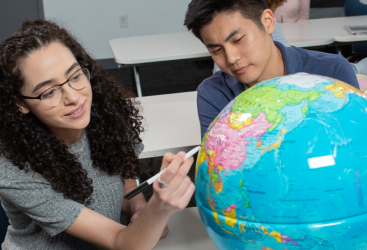 Boy and girl writing on globe